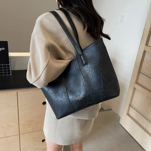 Classic black leather tote bag with gold lettering for elegant office and daily styling