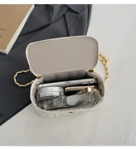 Detailsicht der geräumigen Innenseite der beige gesteppten Kettentasche mit Alltagsartikeln