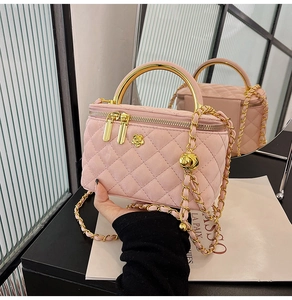 Nahaufnahme der rosa gesteppten Wildleder-Minitasche mit goldener Kamelie und Metallgriff