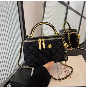Details der schwarzen gesteppten Mini-Box-Tasche mit goldenem Griff und Kette