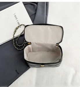 Top view of black quilted vanity bag showing spacious beige fabric interior and chain
