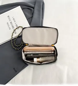 Detail of black quilted box bag interior showing spacious storage for phone and lipstick