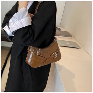 Detail of brown faux leather shoulder bag featuring silver buckles and eyelets decoration