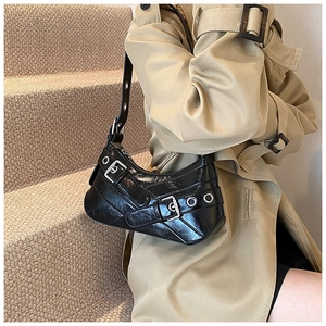 Detail of a black crescent shoulder bag in glossy leather with silver buckles