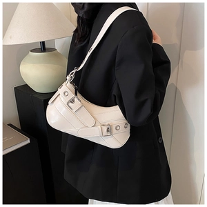 Close-up of cream vintage baguette bag with buckle details and silver hardware