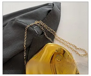 Detailed macro view of the irregular golden mirror metal hardware and fine chain strap