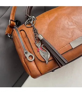 Detail of vintage Boston bag featuring a cat metal charm and stylish tassel accessories