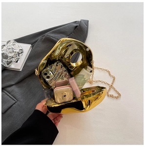 Internal view of gold irregular mirror clutch bag holding phone and cosmetics