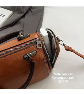 Close-up of the side zipper pocket on a brown vintage Boston bag showing storage space