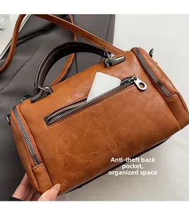 Detail of the back anti-theft zipper pocket on this vintage brown leather barrel bag