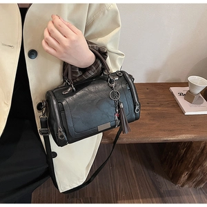 Black pebbled leather Boston bag detail with bronze hardware and cat tassel charm
