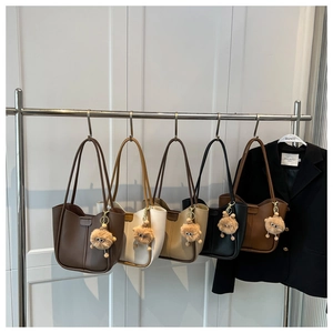 Detailed row of tote bags in five colors featuring cute plush monster charms and matte finish