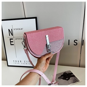 Detail of pink saddle bag with textured glitter flap and metallic bar closure