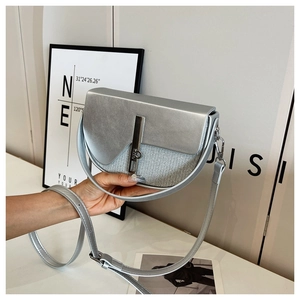 Detail of silver saddle bag showing metallic leather texture and metal buckle lock