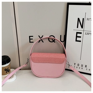 Detail of pink saddle bag with textured woven flap and polished silver metal hardware