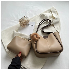 Detail of beige faux leather tote bag with dark brown trim and matching small pouch