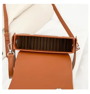 Close-up of the spacious brown leather bag interior with silver buckles and striped lining