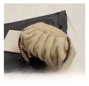 Détail du sac nuage en fausse fourrure beige avec chaîne en cuir brun et métal argenté