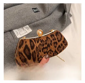 Detail of leopard print evening clutch featuring a large pearl and crystal clasp
