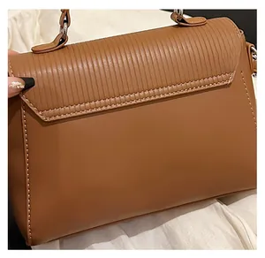 Detail showing vertical pleated texture and white stitching on brown leather handbag