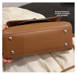 Detail of brown leather bag base with silver studs for anti-scratch protection