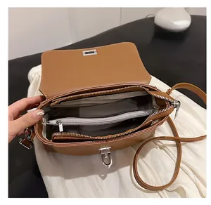 Detail view showing the spacious interior compartment of the brown crossbody handbag