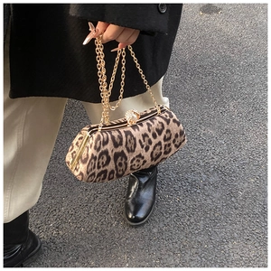Detail of leopard print suede handbag with gold chain and pearl clasp on a coat
