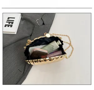 Detail showing the internal capacity of the golden shell acrylic evening clutch bag