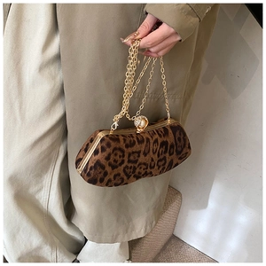 Detailed close-up of leopard print handbag with luxury pearl clasp and gold chain strap