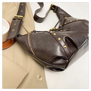 Dettaglio della borsa Hobo marrone scuro con rivetti dorati e fibbia decorativa a tracolla