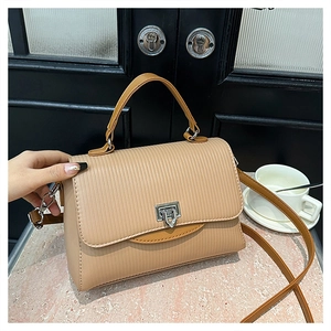 Detail of light brown PU leather handbag with vertical embossing and silver twist lock