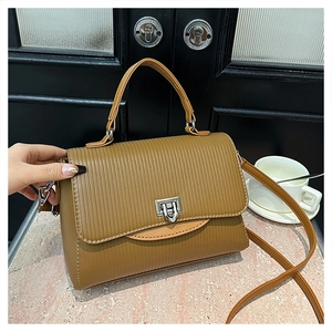 Detail of vintage brown tote bag with vertical embossed texture and silver twist lock