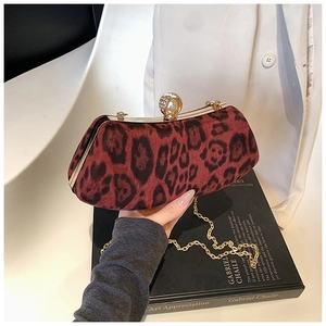 Close-up of red leopard print clutch with gold metal frame and pearl rhinestone clasp