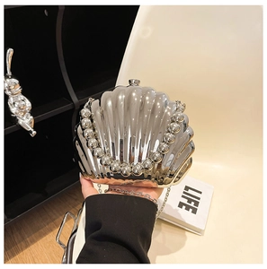 Macro shot of silver shell-shaped evening bag with metallic texture and beaded handle
