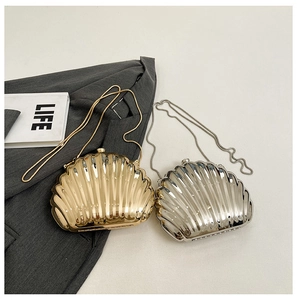 Detail of shell-shaped metallic evening clutch bags in gold and silver with chain straps