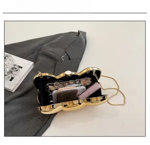 Internal view of gold bow evening clutch showing space for phone and makeup accessories