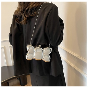 Silver butterfly metal chain bag shown on a model against a white wall back view