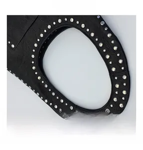Detail of vintage black pebble leather texture with silver rivet studs on the handle