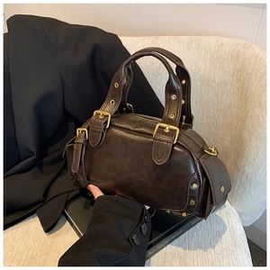 Macro detail of dark brown vintage oil wax leather handbag with golden metal hardware buckles