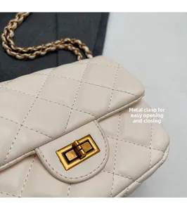 Detail of beige quilted leather cross-body bag with golden rectangular turn-lock closure