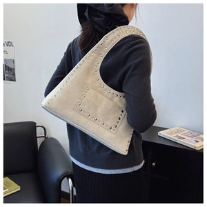Detail of vintage cream rivets shoulder bag with pleated leather and metal stud accents