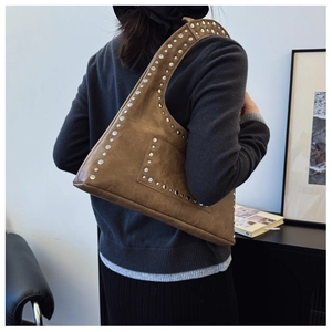 Detail view of brown vintage rivets on a stylish faux leather shoulder bag with wide strap