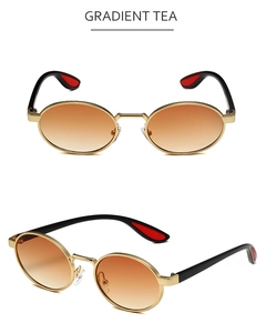 Close-up of retro oval metal sunglasses with gradient tea lenses and gold frame details