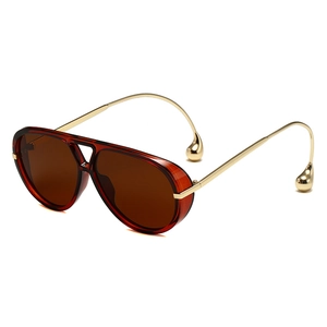 Gafas de sol aviador con montura ámbar y patillas de metal dorado con gotas decorativas