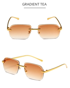Détail de lunettes de soleil carrées sans monture avec verres dégradés et branches dorées