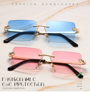 Detailed close-up of rimless rectangle sunglasses with leopard head metal gold ornaments