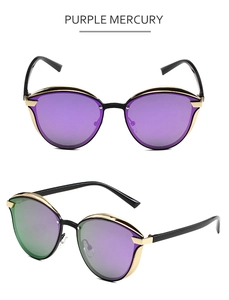 Detail view of cat eye sunglasses with purple mercury lenses and golden metal frames
