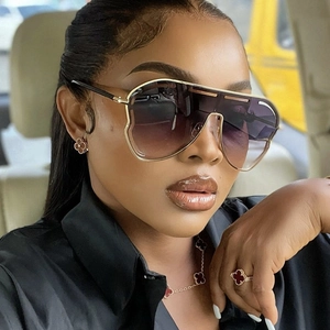 Close-up of stylish oversized gradient aviator sunglasses with gold metal frame