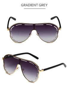 Detailed view of gradient grey oversized sunglasses with gold metal frame and wavy lens edges