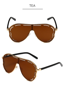 Detail of oversized tea lenses with unique white stitched pattern on gold metal frame